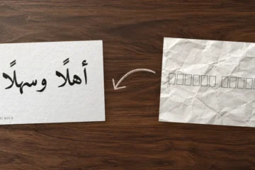 ورقة مجعّدة تظهر فيها مربعات فارغة بدل الحروف، وسهم بقلم الرصاص، ثم بطاقة نظيفة كُتب عليها «أهلًا وسهلًا» بخط Amiri Bold