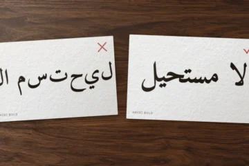 بطاقتان على مكتب: في الأولى «لا مستحيل» بخط أميري بحروف منفصلة مقلوبة وعلامة خطأ، وفي الثانية العبارة متصلة صحيحة وعلامة صح